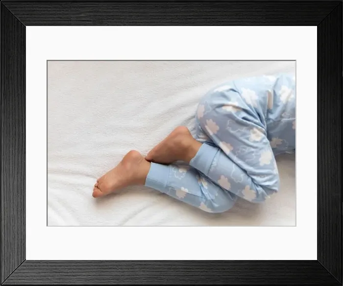 Framed Print : feet of preschool baby boy on blue pajama lying on white bed at home Framed Print : feet of preschool baby boy on blue pajama lying on white bed at home