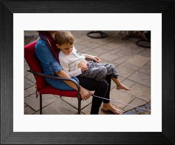 Framed Print : the bottom half of a mother with a small child in her lap Framed Print : the bottom half of a mother with a small child in her lap