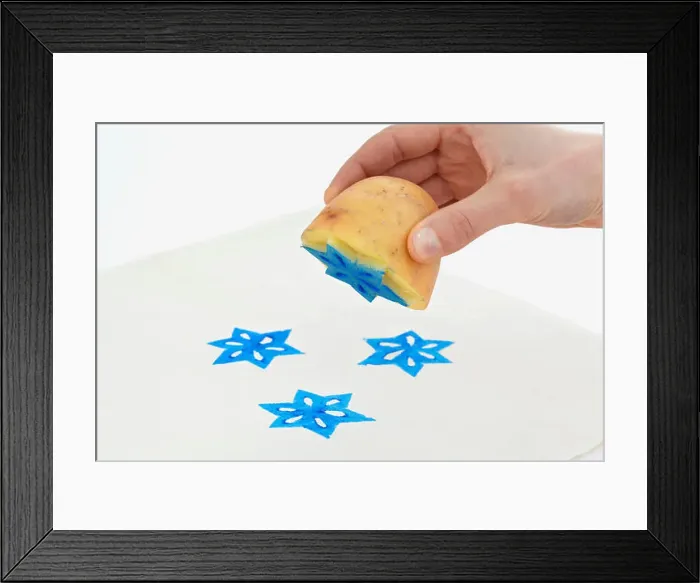 Framed Print : Printing star shapes onto white paper using potato print technique Framed Print : Printing star shapes onto white paper using potato print technique