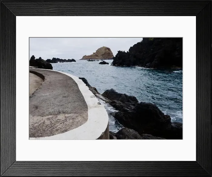 Framed Print : Curved concrete walkway leads to the rocky coastline and serene waters at Porto Moniz natural pools Framed Print : Curved concrete walkway leads to the rocky coastline and serene waters at Porto Moniz natural pools