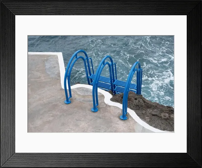 Framed Print : Bright blue ladder leads into the churning ocean waters at Porto Moniz natural pools Framed Print : Bright blue ladder leads into the churning ocean waters at Porto Moniz natural pools