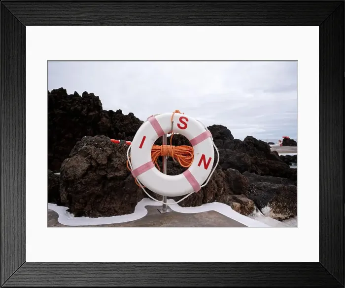 Framed Print : A lifebuoy with orange rope stands ready against dark volcanic rocks at Porto Moniz natural pools Framed Print : A lifebuoy with orange rope stands ready against dark volcanic rocks at Porto Moniz natural pools