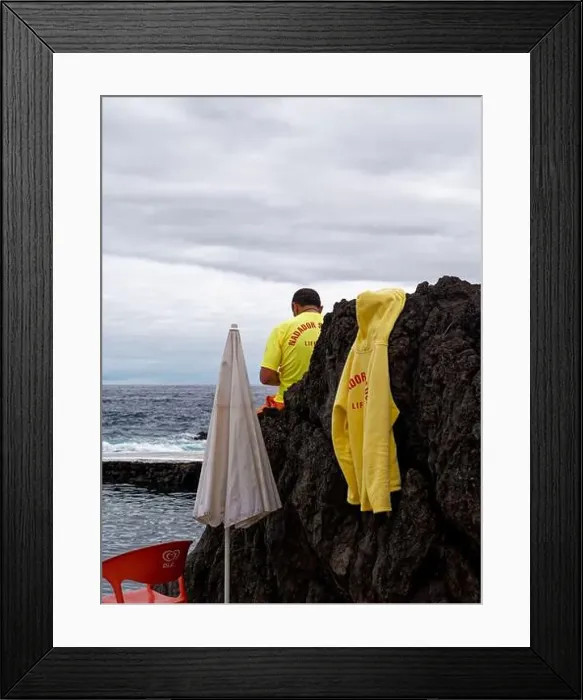 Framed Print : A lifeguard sits on a volcanic boulder Framed Print : A lifeguard sits on a volcanic boulder