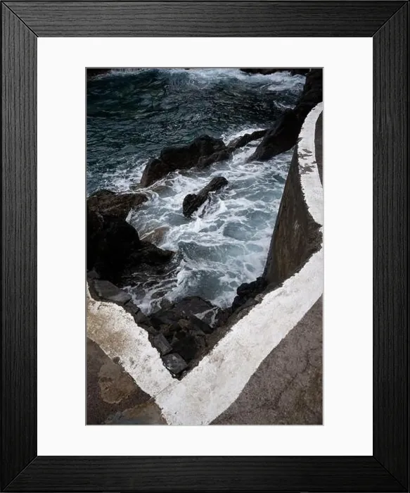 Framed Print : Waves crash against volcanic rocks beneath a sharp concrete edge at Porto Moniz natural pools Framed Print : Waves crash against volcanic rocks beneath a sharp concrete edge at Porto Moniz natural pools