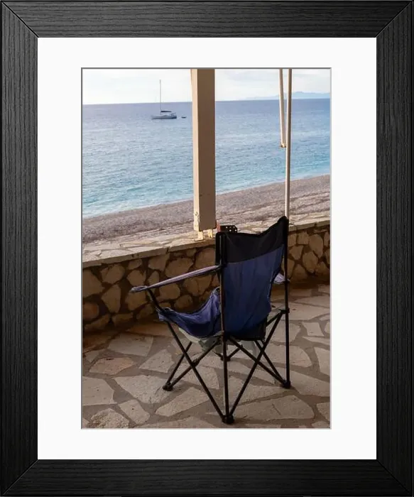 Framed Print : A folding chair on the covered patio of a seaside building with a great view of the sea and sunset sky clouds Framed Print : A folding chair on the covered patio of a seaside building with a great view of the sea and sunset sky clouds