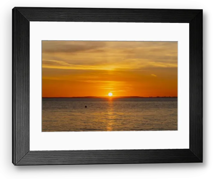 Framed Print : The sun about to set over the Welsh coast with a reddish orangey glow along the horizon Framed Print : The sun about to set over the Welsh coast with a reddish orangey glow along the horizon