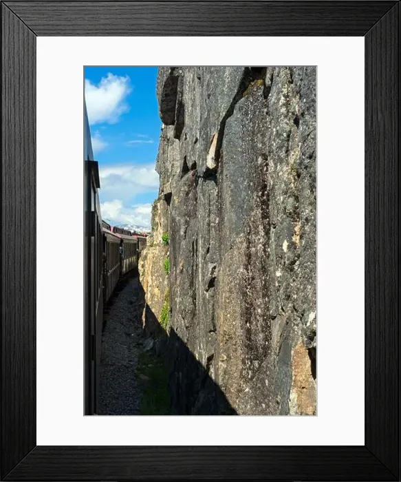 Framed Print : Train on the White Pass and Yukon Route railroad out of Skagway, Alaska, runs next to sheer rock cliffs Framed Print : Train on the White Pass and Yukon Route railroad out of Skagway, Alaska, runs next to sheer rock cliffs