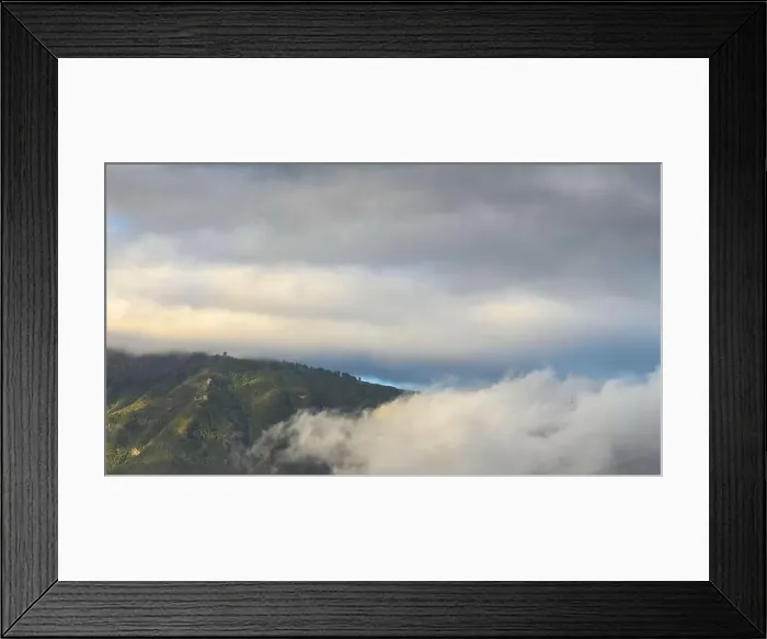 Framed Print : Lush green mountain in Tenerife partially covered by low clouds with a moody sky overhead Framed Print : Lush green mountain in Tenerife partially covered by low clouds with a moody sky overhead