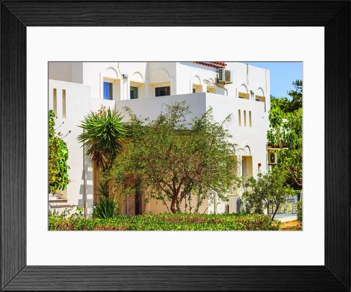Framed Print : Mediterranean-style building surrounded by green bushes, plants, and tree on sunny day. Crete. Greece Framed Print : Mediterranean-style building surrounded by green bushes, plants, and tree on sunny day. Crete. Greece
