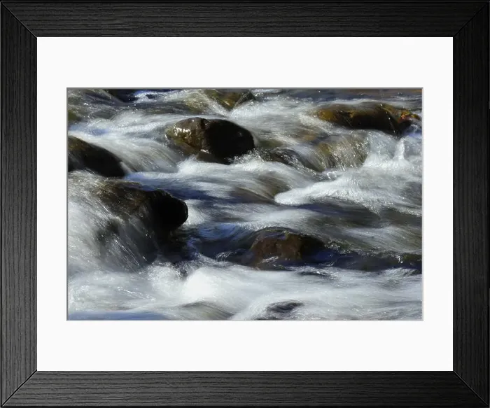 Framed Print : Environment. Fast-flowing crystal clear water flows by rocks in a large stream Framed Print : Environment. Fast-flowing crystal clear water flows by rocks in a large stream