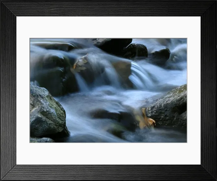 Framed Print : Environment. Fast-flowing crystal clear water flows by rocks in a large stream Framed Print : Environment. Fast-flowing crystal clear water flows by rocks in a large stream