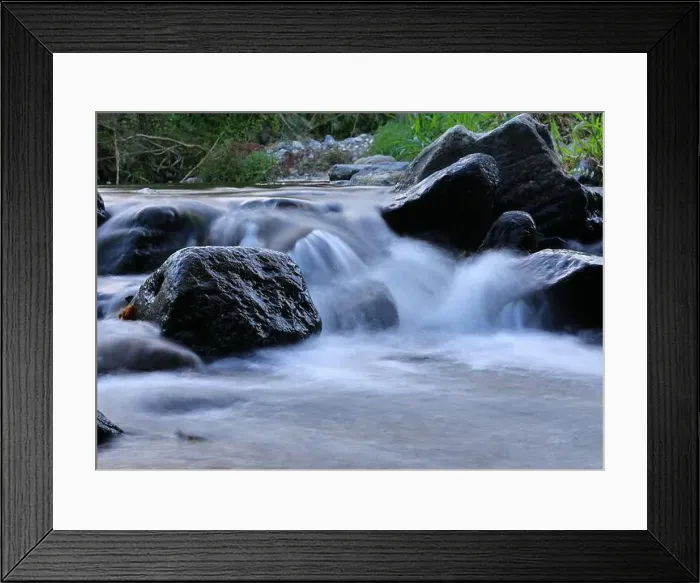 Framed Print : Environment. Fast-flowing crystal clear water flows by rocks in a large stream Framed Print : Environment. Fast-flowing crystal clear water flows by rocks in a large stream