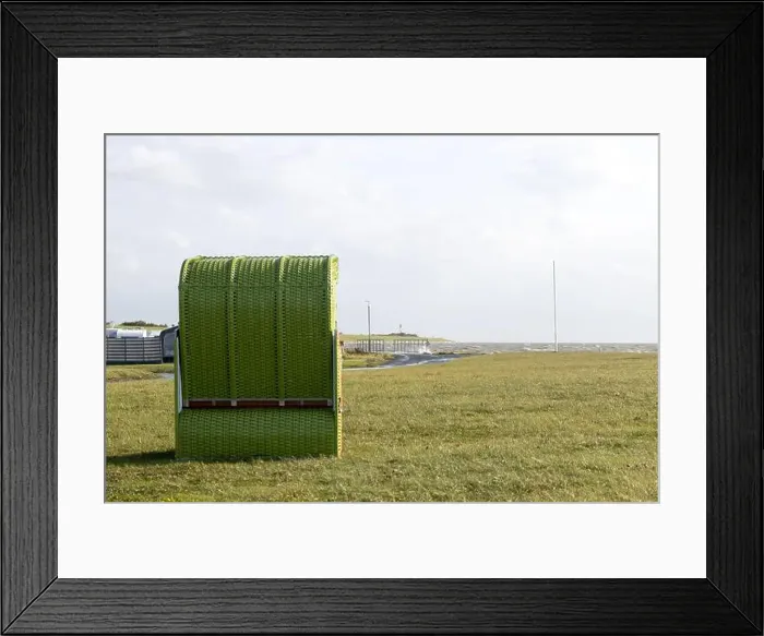 Framed Print : A solitary green beach chair stands on a grassy field by the sea Framed Print : A solitary green beach chair stands on a grassy field by the sea