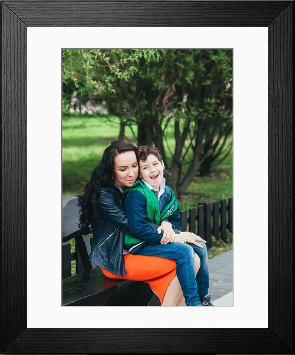 Framed Print : Cute little boy sit son his mother's lap in the park. A mother's love and tenderness Framed Print : Cute little boy sit son his mother's lap in the park. A mother's love and tenderness