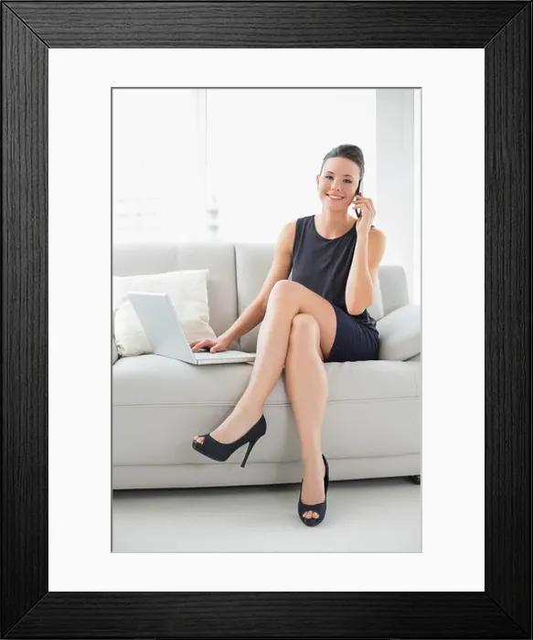 Framed Print : Beautiful well dressed woman using laptop and cellphone Framed Print : Beautiful well dressed woman using laptop and cellphone