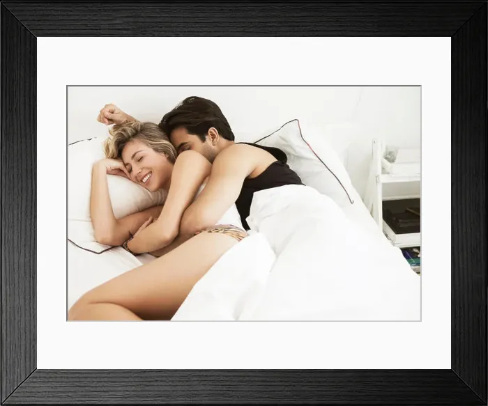 Framed Print : Happy couple lying on bed at home Framed Print : Happy couple lying on bed at home