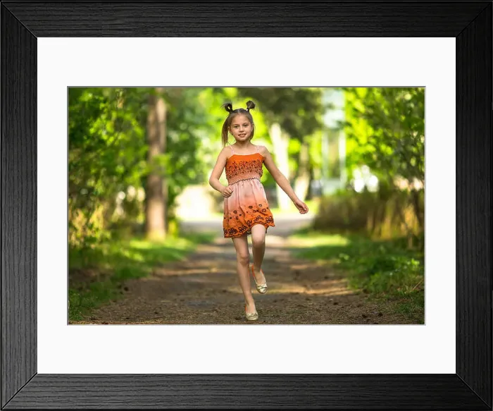 Framed Print : Cheerful little girl running along a path in a park Framed Print : Cheerful little girl running along a path in a park