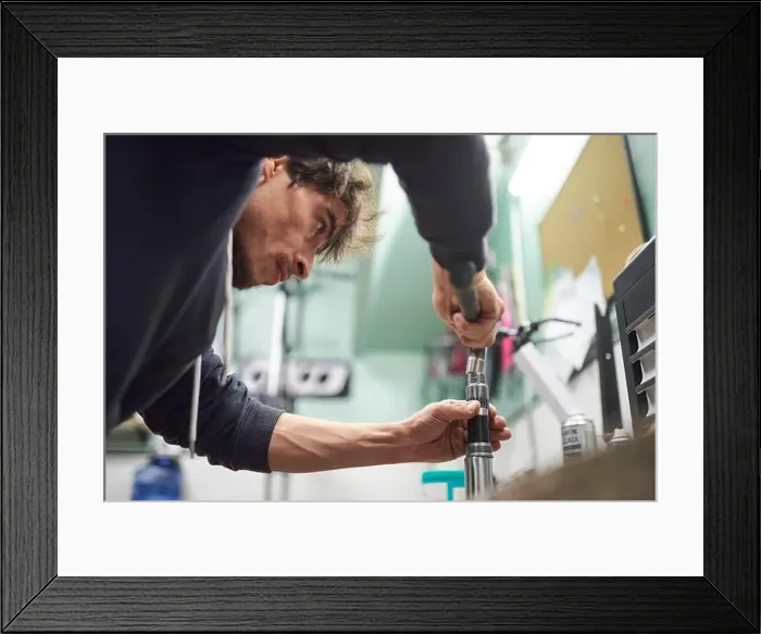 Framed Print : Young hispanic man servicing a bicycle in his repair shop. Real people at work. Composition with copy space Framed Print : Young hispanic man servicing a bicycle in his repair shop. Real people at work. Composition with copy space