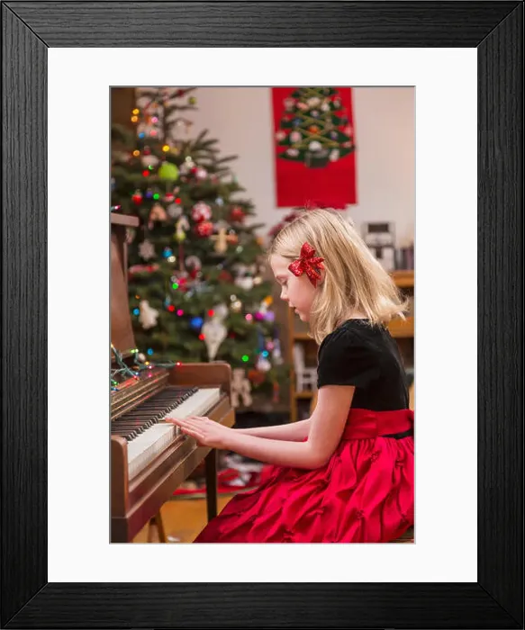 Framed Print : Six Year Old Girl Wearing A Formal Dress, Red Bow In Her Hair, Playing The Piano, Christmas Tree In The Background Framed Print : Six Year Old Girl Wearing A Formal Dress, Red Bow In Her Hair, Playing The Piano, Christmas Tree In The Background