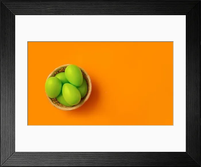 Framed Print : Easter concept. Simple composition with green eggs in basket on vibrant orange background Framed Print : Easter concept. Simple composition with green eggs in basket on vibrant orange background