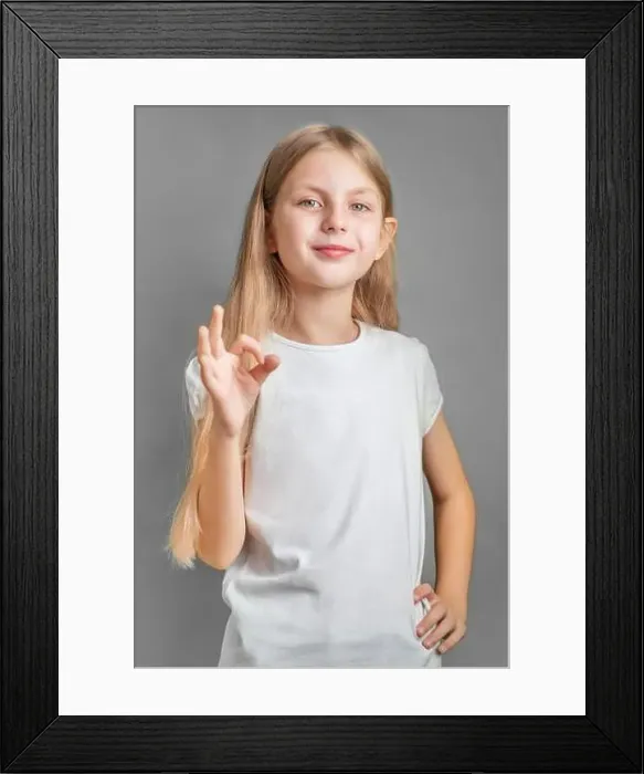 Framed Print : A little blonde girl shows the ok sign with her hand Framed Print : A little blonde girl shows the ok sign with her hand