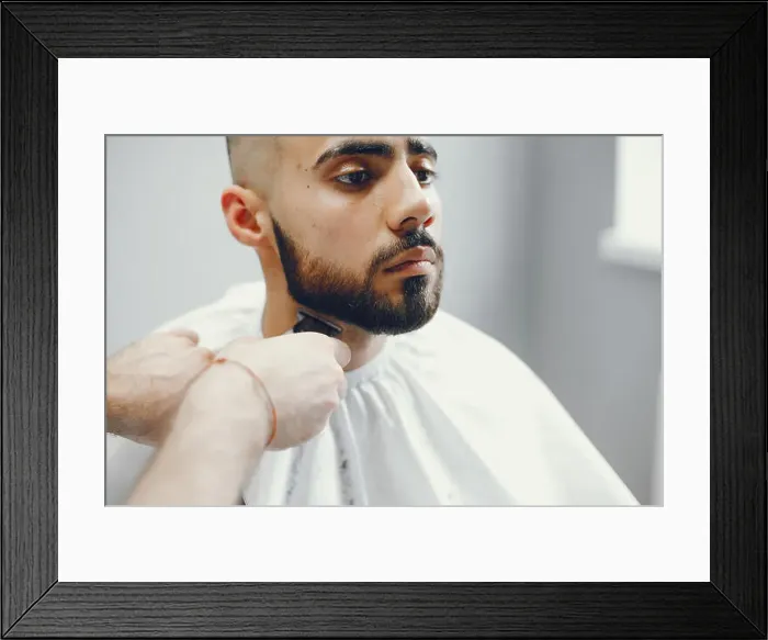 Framed Print : The man cuts his beard in the barbershop Framed Print : The man cuts his beard in the barbershop
