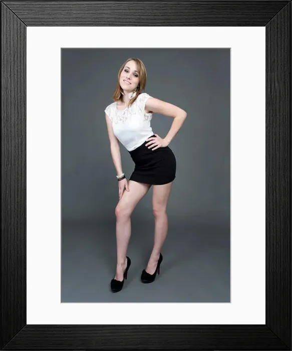 Framed Print : Young woman wearing a white top, a short black skirt and high heels
