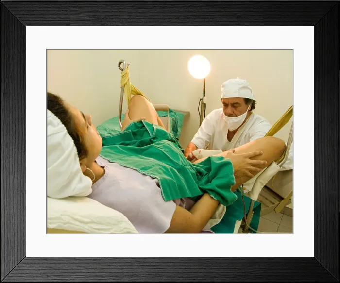 Framed Print : Doctor receiving a child in a natural birth Framed Print : Doctor receiving a child in a natural birth