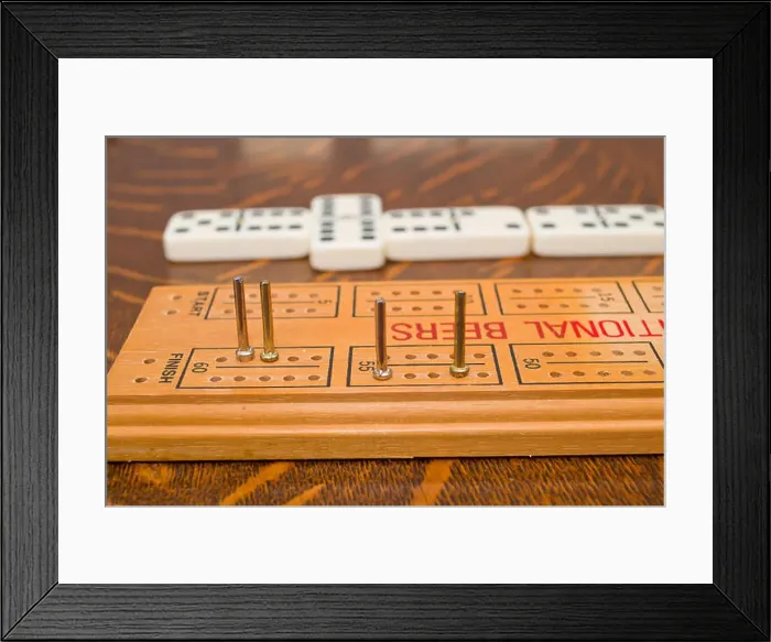 Framed Print : Scoring dominoes using cribbage board or peg board Framed Print : Scoring dominoes using cribbage board or peg board