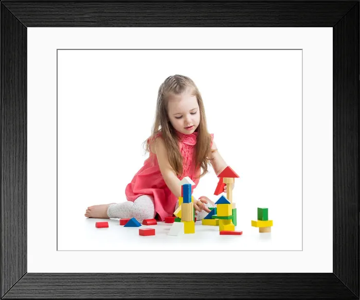 Framed Print : child girl playing with block toys over white background Framed Print : child girl playing with block toys over white background