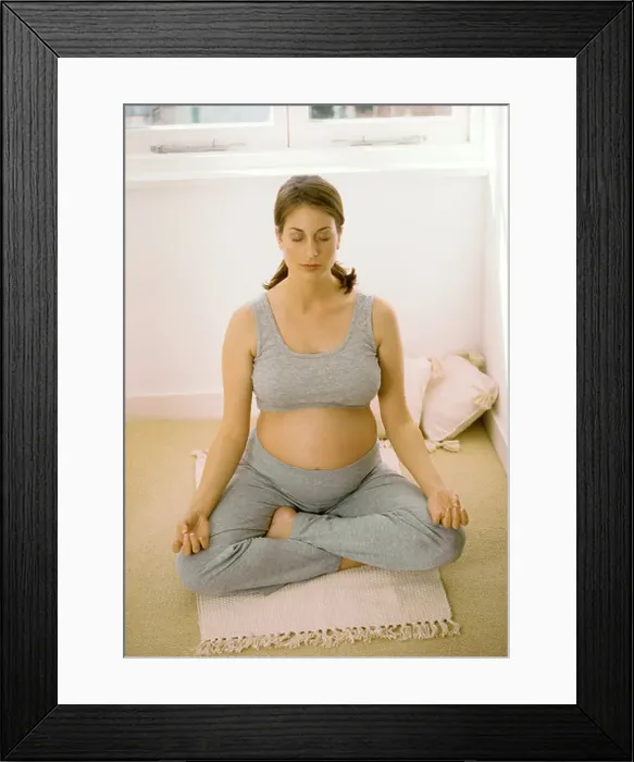 Framed Print : Heavily pregnant woman performing yoga for relaxation indoors
