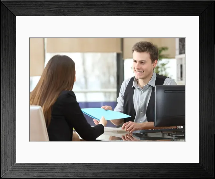 Framed Print : Businessman giving documents to a client sitting at office during an interview Framed Print : Businessman giving documents to a client sitting at office during an interview