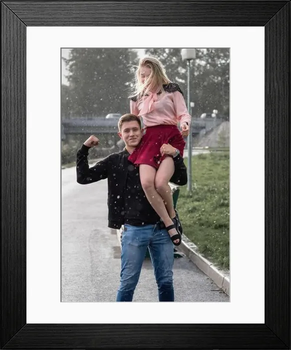 Framed Print : Strong man carrying his woman on shoulder in the street on rain Framed Print : Strong man carrying his woman on shoulder in the street on rain