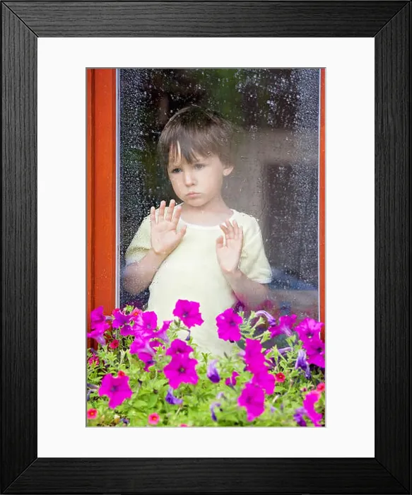 Framed Print : Little boy behind the window in the rain, looking sad Framed Print : Little boy behind the window in the rain, looking sad