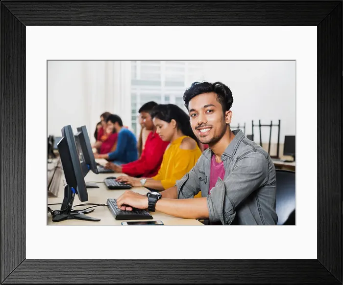 Framed Print : Young Male College Student Using Computer Studying E-Learning Education With Students In Computer Class Framed Print : Young Male College Student Using Computer Studying E-Learning Education With Students In Computer Class