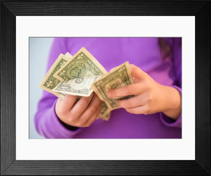 Framed Print : Girl (8-9) counting money Framed Print : Girl (8-9) counting money