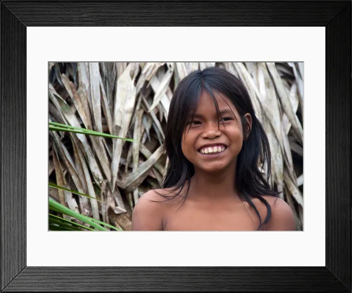 Framed Print : A smiling Matses Mayorunas young girl in front of a maloca (traditional house), Amazonian Peru Framed Print : A smiling Matses Mayorunas young girl in front of a maloca (traditional house), Amazonian Peru