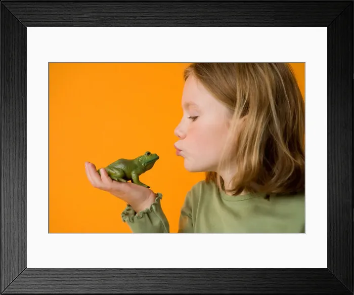 Framed Print : blond girl kissing toy frog to make a wish