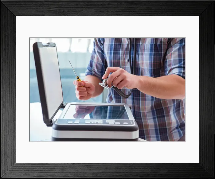 Framed Print : Repairman repairing broken color printer