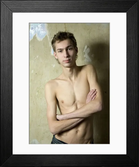 Framed Print : portait of young bare serious man with pirsing in eyebrow standing opposite the wall Framed Print : portait of young bare serious man with pirsing in eyebrow standing opposite the wall
