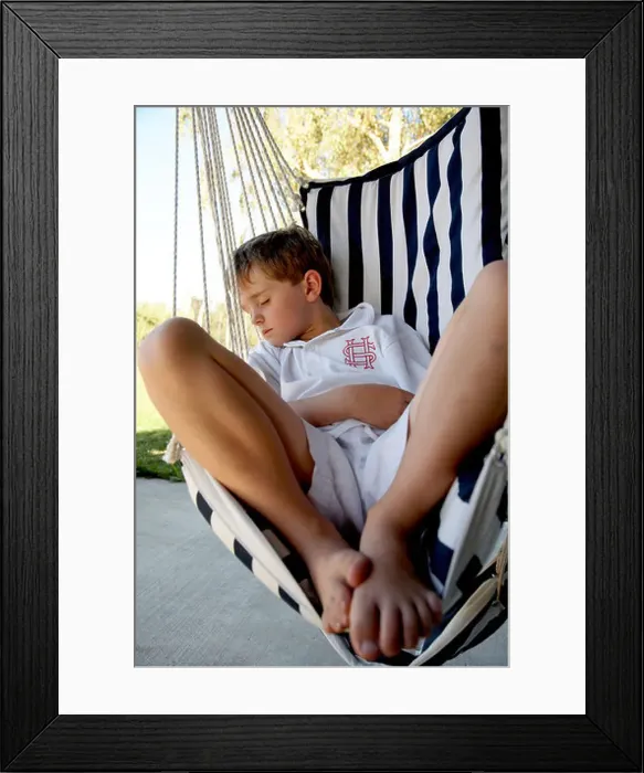 Framed Print : young boy asleep outside in rope chair after school