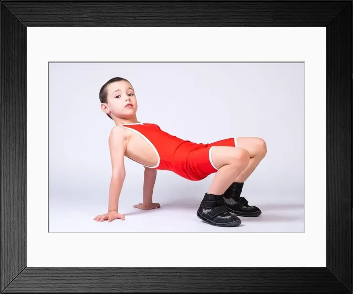 Framed Print : A boy athlete in sportswear and wrestling outfits does an exercise Framed Print : A boy athlete in sportswear and wrestling outfits does an exercise