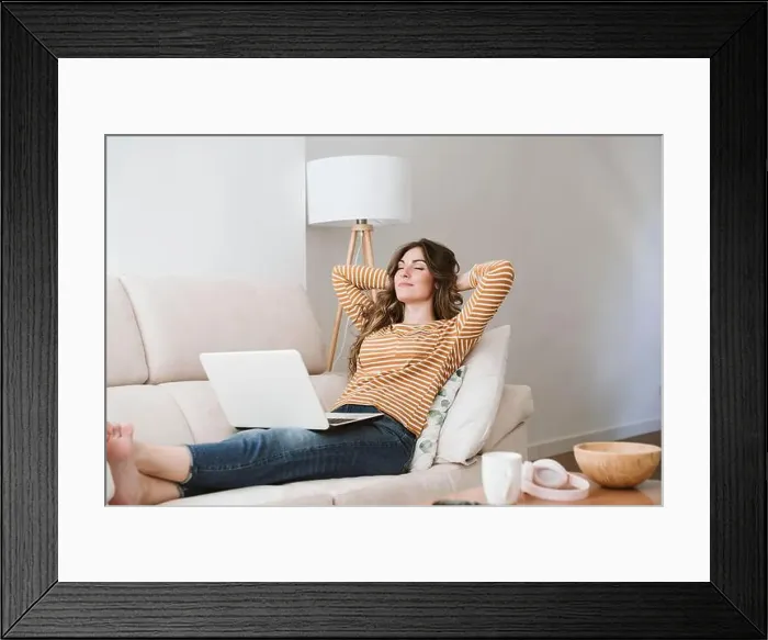 Framed Print : Young woman with laptop relaxing on sofa at home Framed Print : Young woman with laptop relaxing on sofa at home