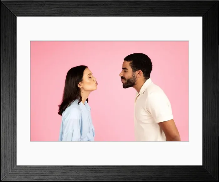 Framed Print : Romantic millennial couple reaching each other with kissing lips Framed Print : Romantic millennial couple reaching each other with kissing lips
