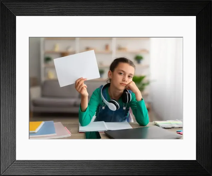 Framed Print : Portrait of bored teenage girl sitting at table Framed Print : Portrait of bored teenage girl sitting at table