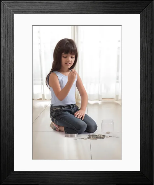 Framed Print : little girl with coin box and coins on floor Framed Print : little girl with coin box and coins on floor