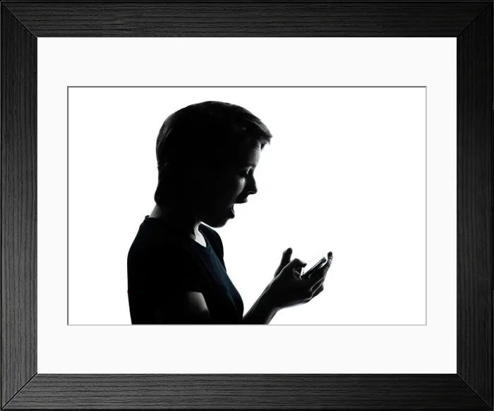 Framed Print : one caucasian young teenager silhouette girl telephone videophone video game portrait in studio cut out isolated Framed Print : one caucasian young teenager silhouette girl telephone videophone video game portrait in studio cut out isolated