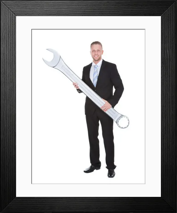 Framed Print : Handsome bearded businessman in a smart suit holding a large metal spanner in his hands conceptual of problem solving Framed Print : Handsome bearded businessman in a smart suit holding a large metal spanner in his hands conceptual of problem solving