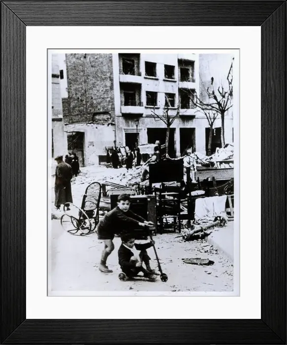 Framed Print : Guerra civil española. Niños jugando con un patinete entre las ruinas de un bombardeo. Año 1938 Framed Print : Guerra civil española. Niños jugando con un patinete entre las ruinas de un bombardeo. Año 1938