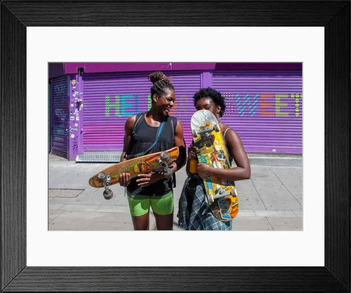 Framed Print : Two young women holding skateboards on a hot summers day in London's Camden Town Framed Print : Two young women holding skateboards on a hot summers day in London's Camden Town